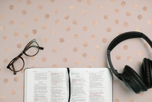 reading glasses, open Bible, and headphones 