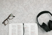reading glasses, headphones, and open Bible 
