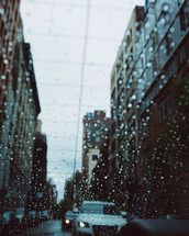 rain on a rear window in a car in traffic 