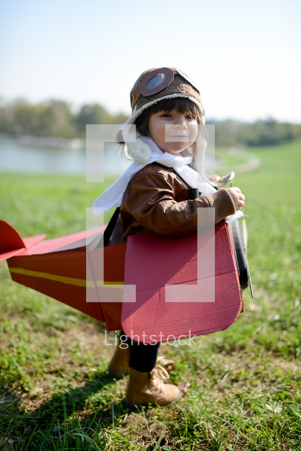 a child in a cardboard box airplane 