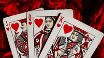 Cards for gambling on roses. Blackjack poker concept. Queen, king, jack of hearts on red roses background. High quality photo