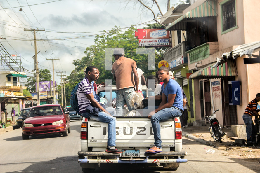 men crammed in the back of a pickup truck 