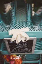 A sign reading, "You are a blessing," on a stack of blue metal shelves.