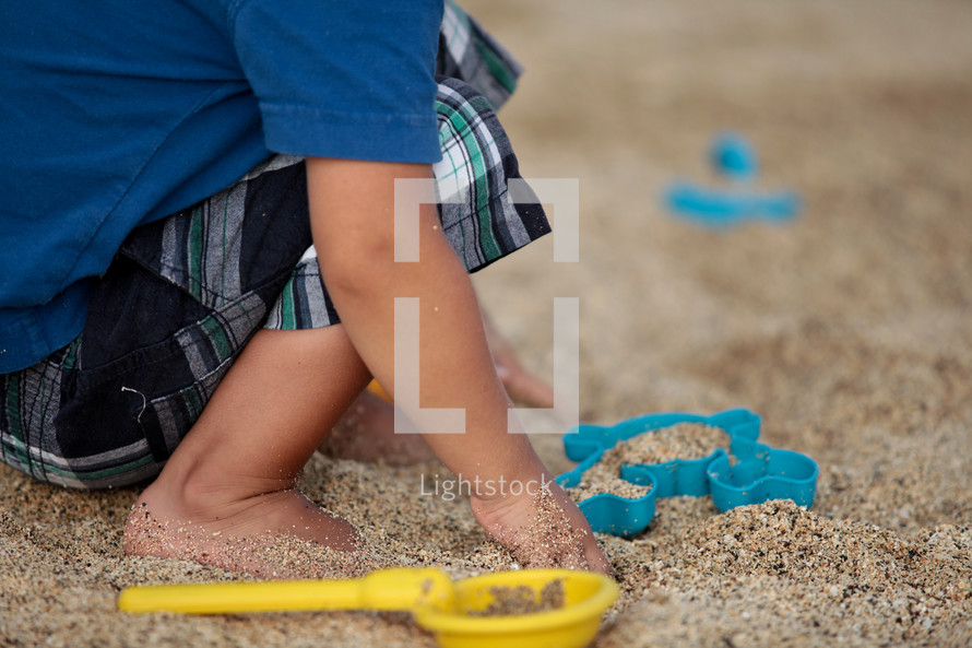 a toddler playing in sand 