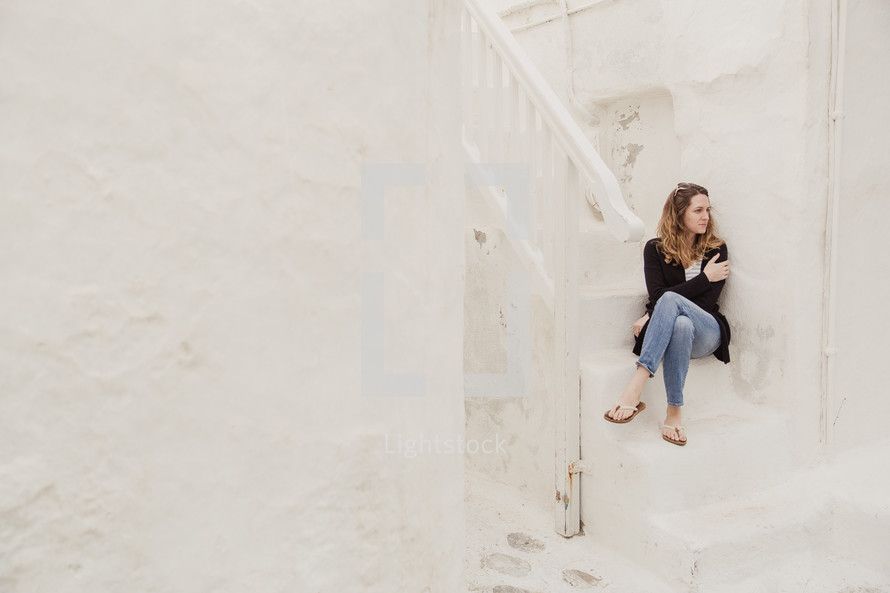 woman sitting on white steps in Greece 