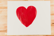 painted red heart on white paper 
