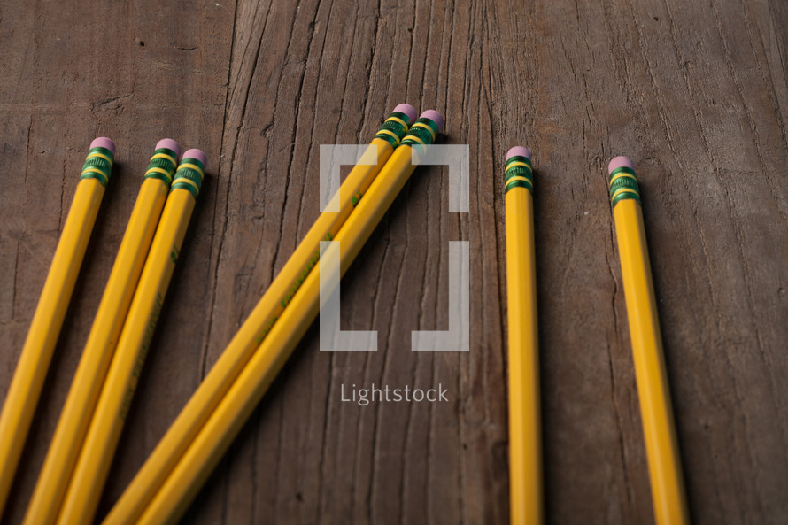 Yellow pencils on a wooden surface.