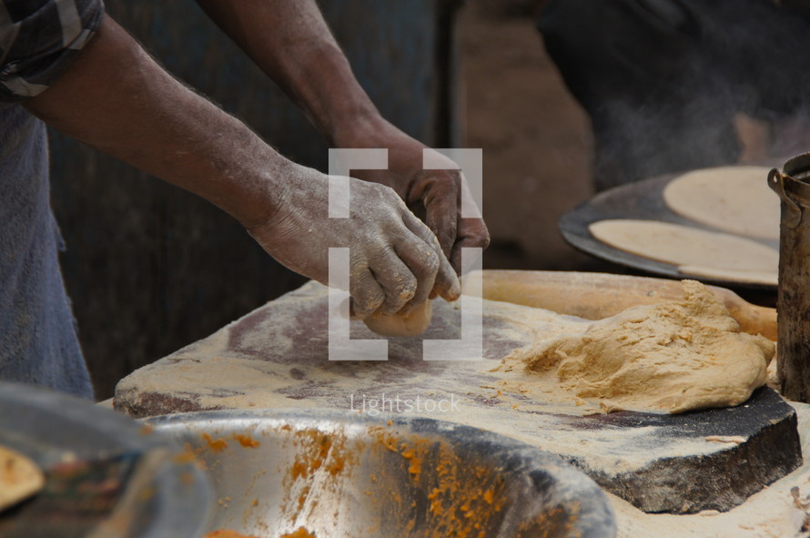 Man kneading dough in an indian bakery