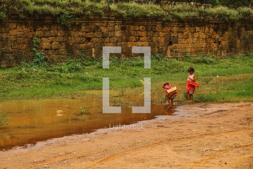 girl's playing in a puddle in Cambodia 