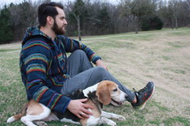 a man sitting with his beagle dog