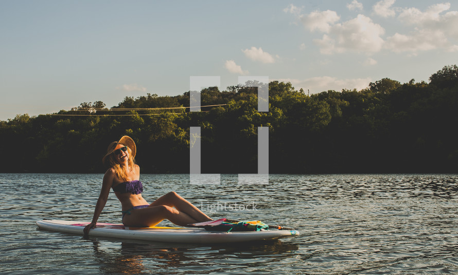 woman sitting on a paddle board 