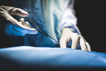 Hands of surgeon in operating room.