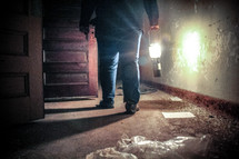man with a lantern walking through an abandoned building 