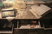 debris and ceiling tiles on a desk in an abandoned building 