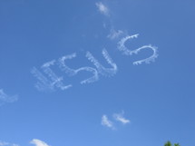 The name of Jesus appears in the sky as a small crop duster airplane circles the sky overhead writing out the name of Jesus to minister to people who take time to look up and see this marvelous name.
