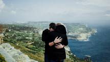 a couple hugging with an ocean view 