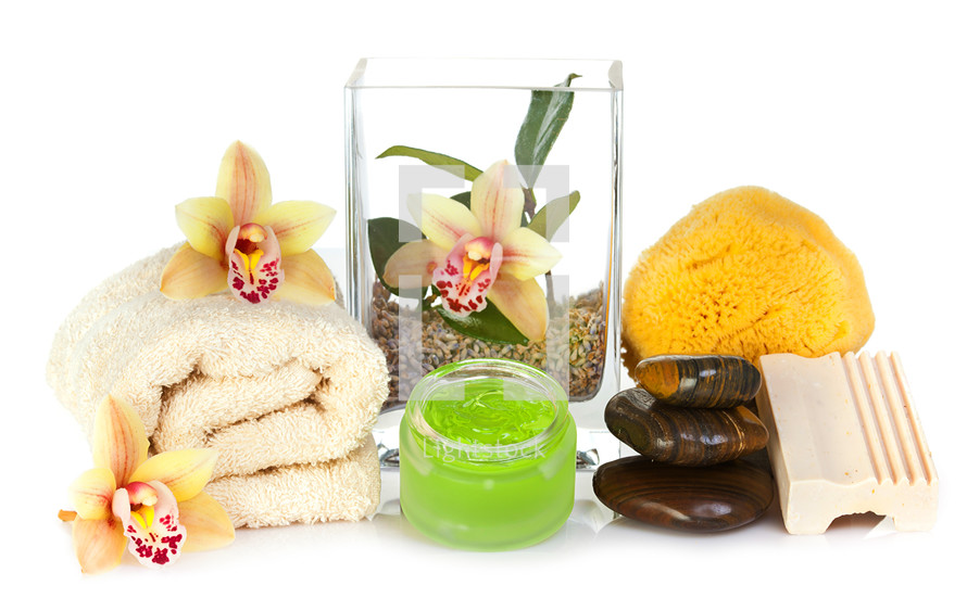 Accessories for spa with soap bar, orchid flowers, stones, sponge and towel on white background