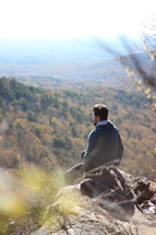 a man resting on a mountaintop 