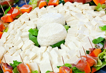 Ricotta cheese, typical Italian cheese product, surrounded by ham and melon.
