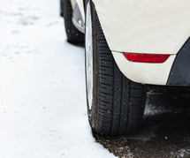 Car tire in winter on the road.