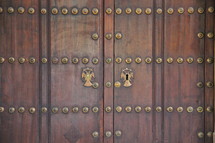 wood door with gold decorative button detail 