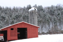 red barn and silo and snow on the ground