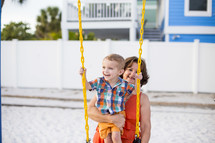 grandmother pushing her grandson on a swing 