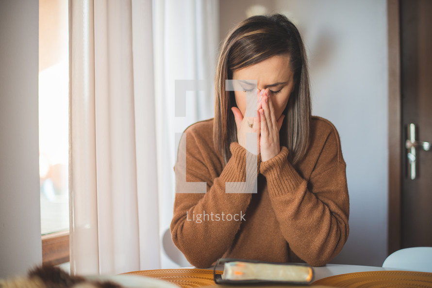 a woman crying sitting with a Bible 