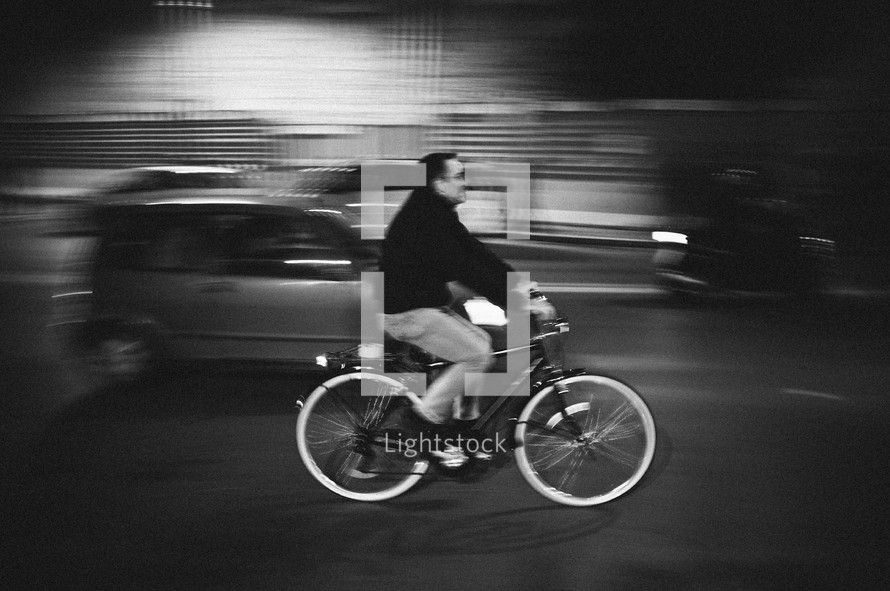 man riding his bicycle on a busy street