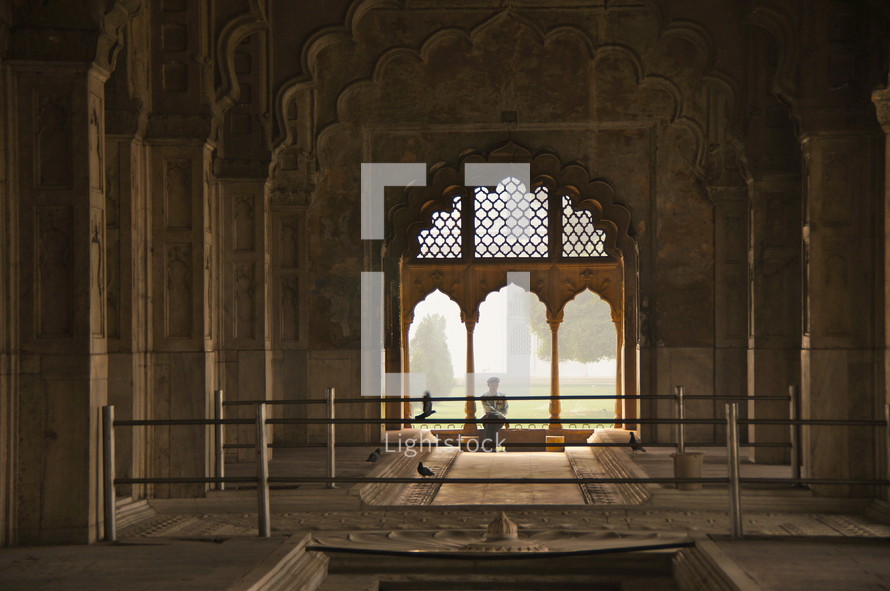 man sitting in the window of a palace mosque