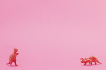 dinosaur figurine on pink background 