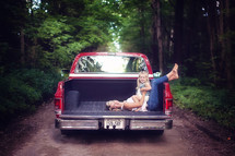 mother and daughter in the back of a truck on a dirt road 