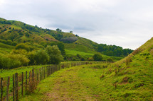fence line and green hills 