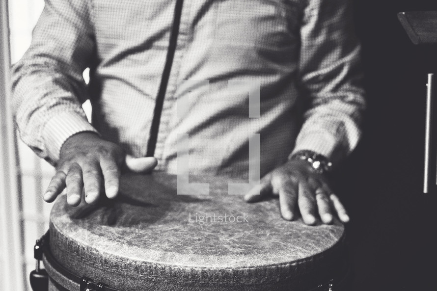 hands on a bongo drum 