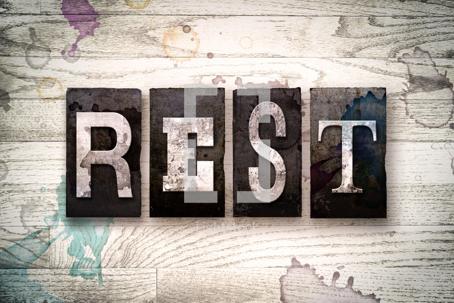 word rest on a white wash wood background 