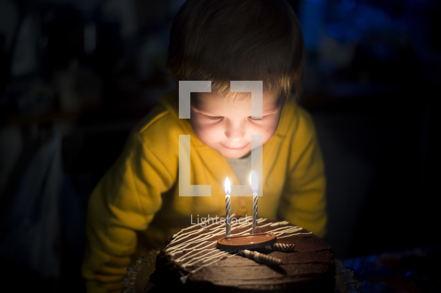 a child blowing out birthday candles 