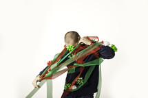 Christmas consumerism - man wrapped up and trapped in Christmas ribbon