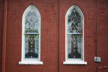 stained glass windows on a brick church 