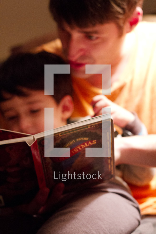 a father reading a Christmas story to his son 