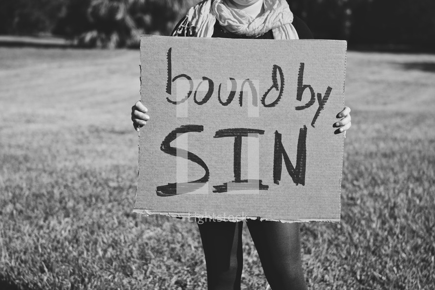 Girl holding "Bound By Sin" sign