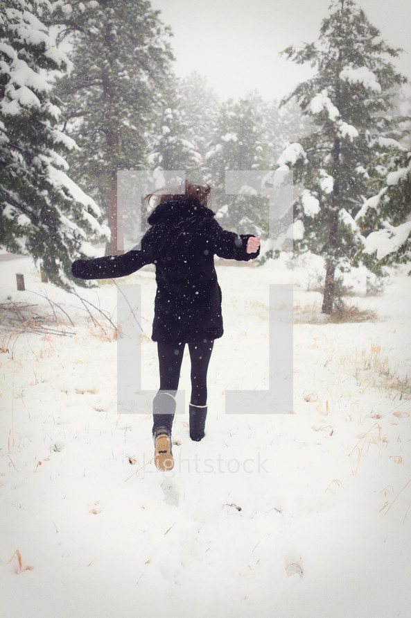 Woman running in a field of winter snow