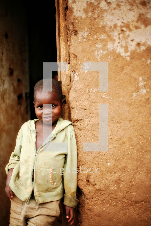 A young boy leaning against a wall
