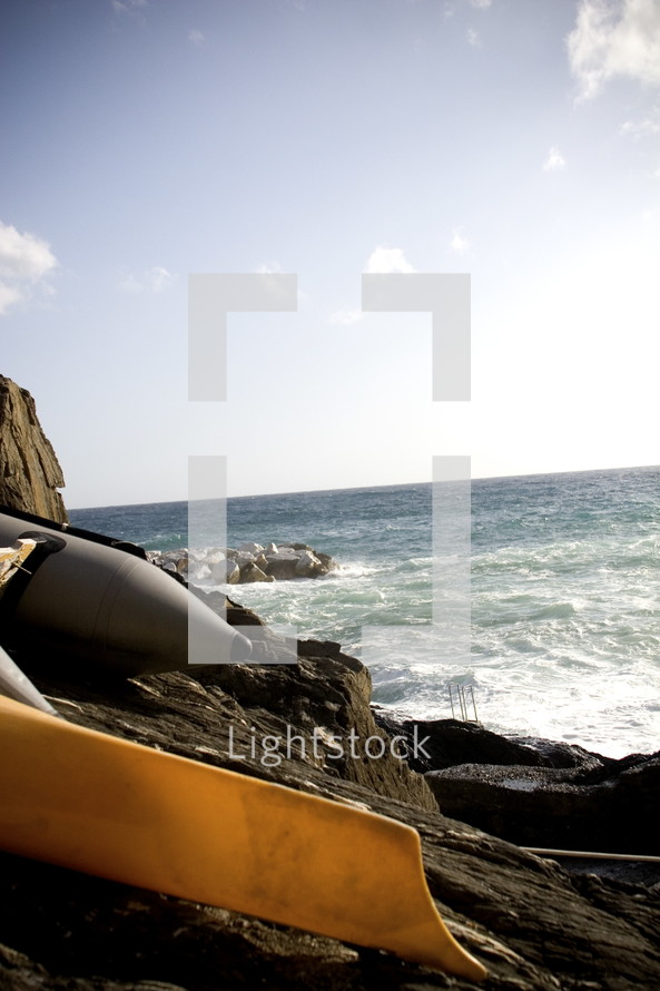 pontoon rafts and canoes on a rocky shore