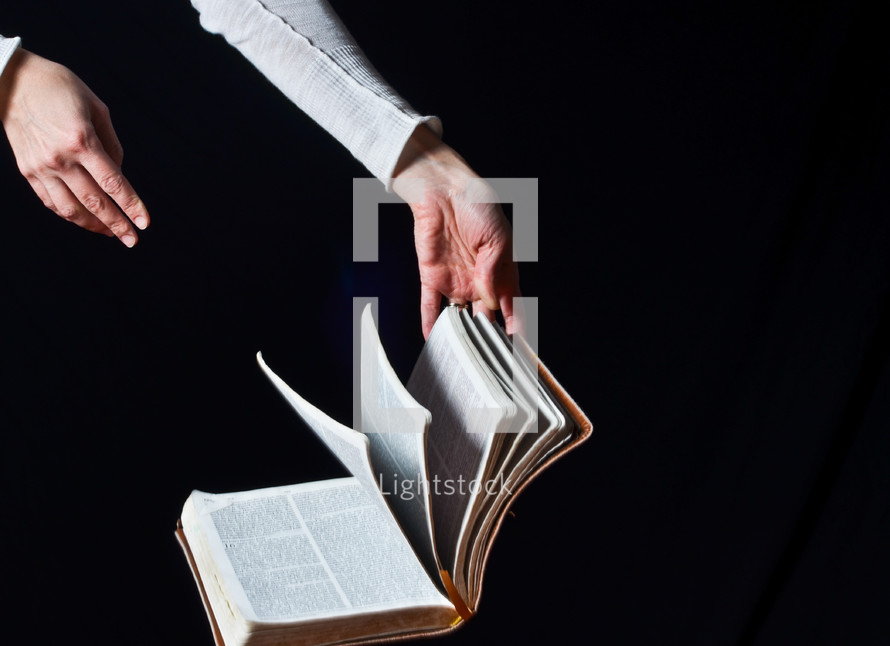 hand flipping the pages of a Bible