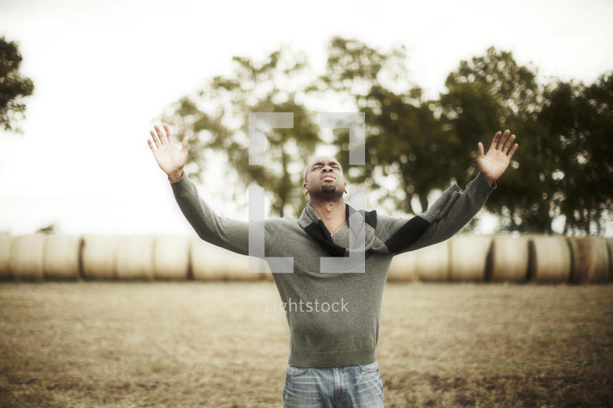 An African American man with raised hands in worship