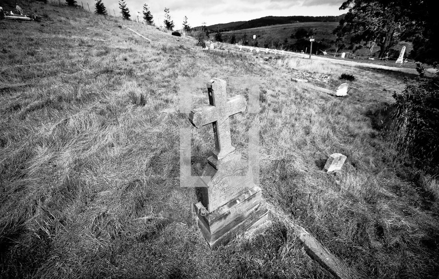 Cross headstone in hillside cemetary.