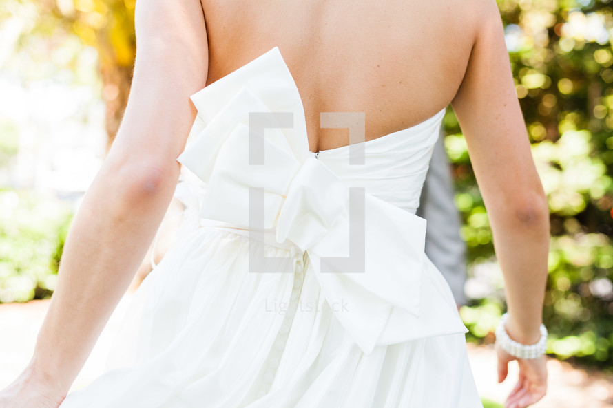 Back of women's dress bridal gown with large white bow