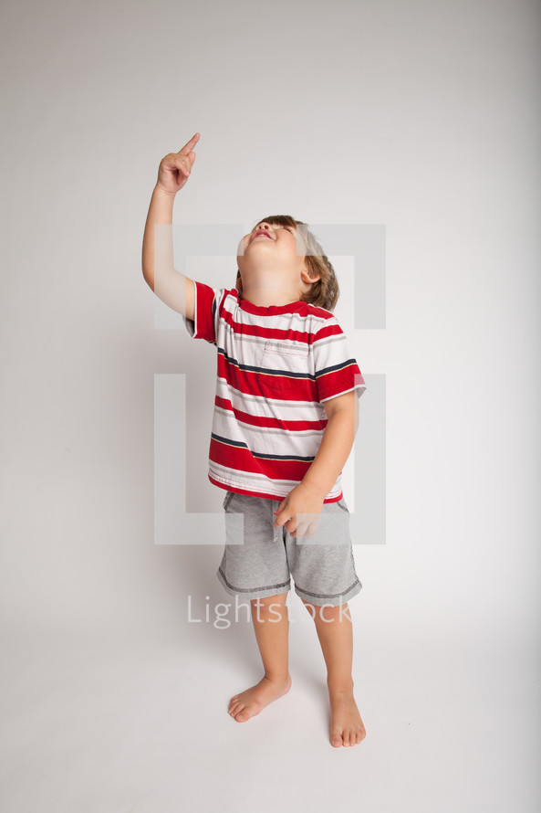 little boy looking and pointing up 