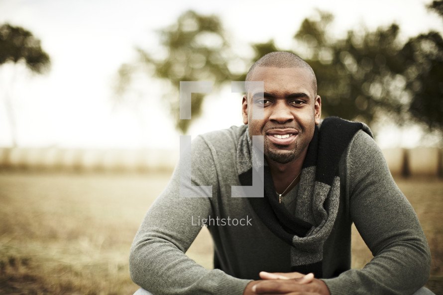 Man sitting in a field smiling