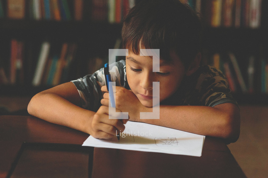 Boy drawing in a library